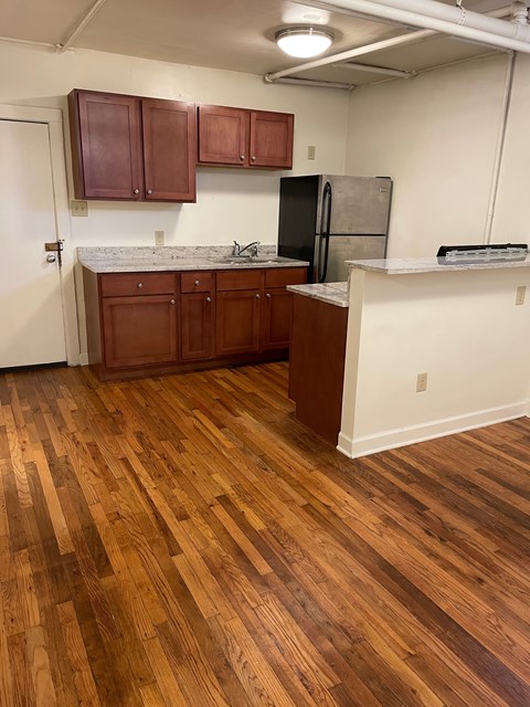 A kitchen with wooden floors and white walls.